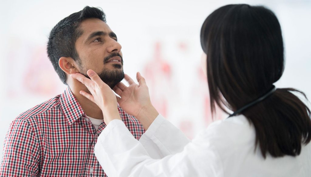 a doctor examines the neck of a patient