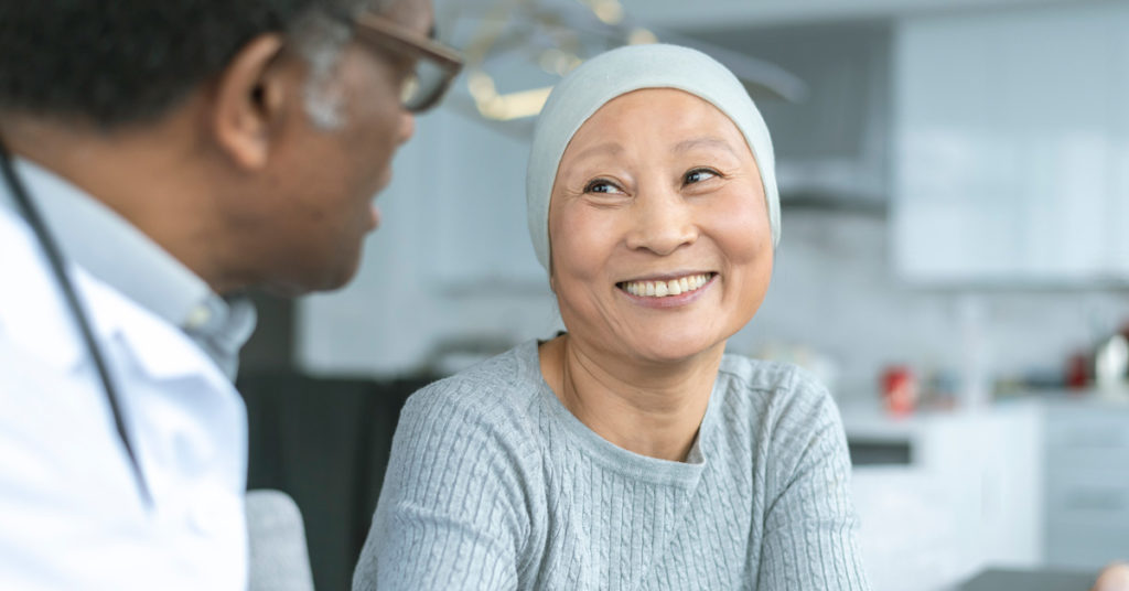 a female cancer patient smiles at a doctor