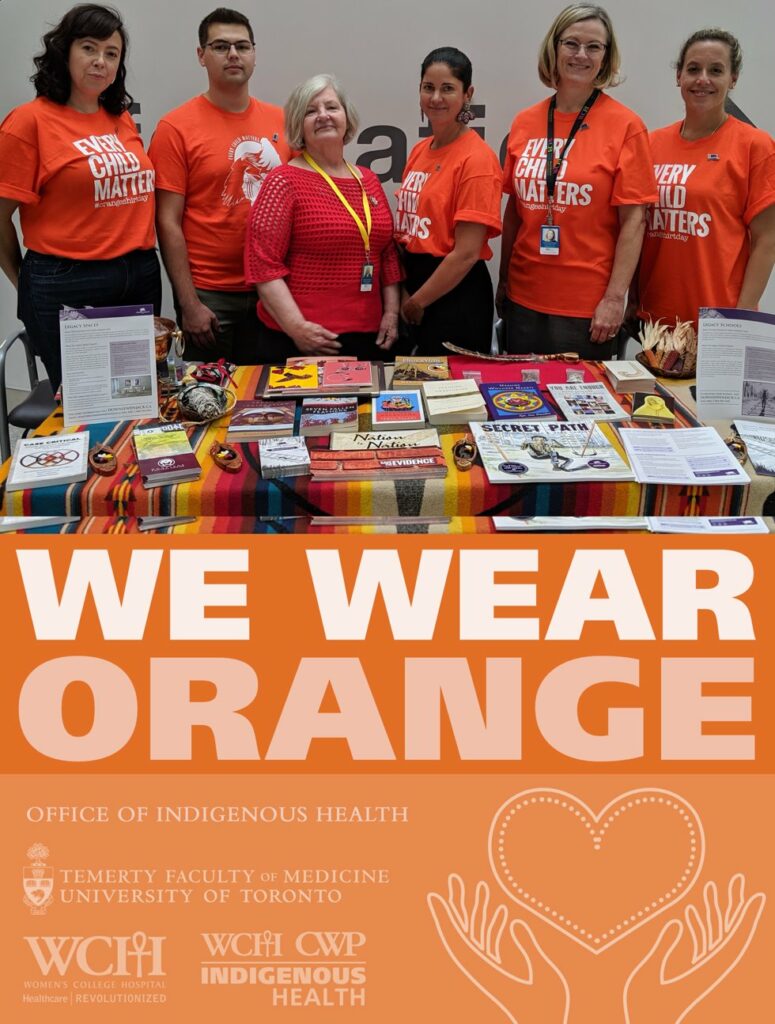 Centre for Wise Practices in Indigenous Health team wearing orange shirts that say "Every Child Matters", at a table with Indigenous resources. Under the photo is text that says We Wear Orange.