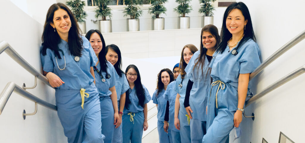 A group of physicians and nurses in scrubs on a stairwell
